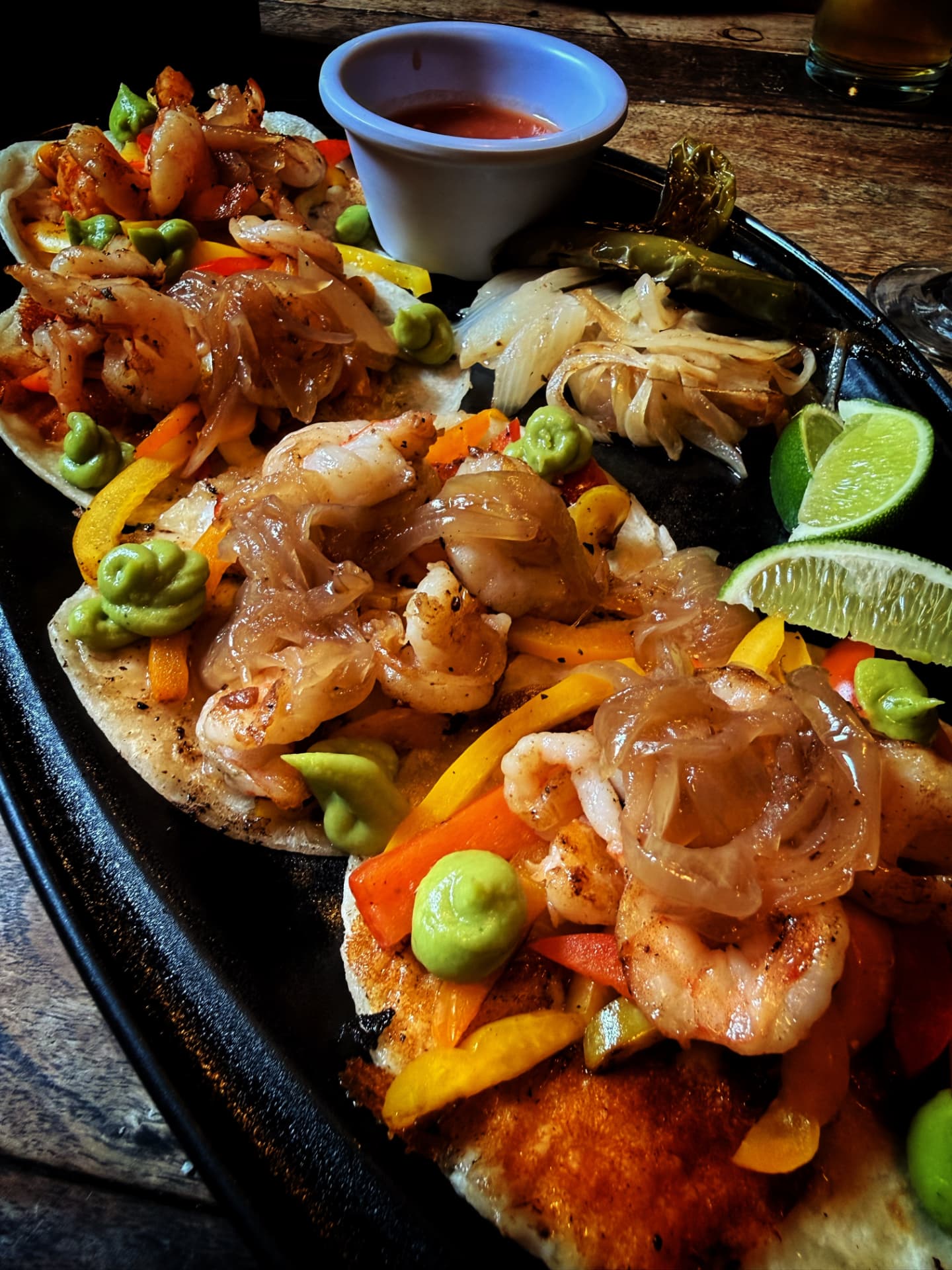 Shrimp tacos with lime on a hot cast iron platter